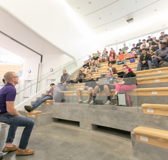 Students listening to faculty member in lecture room