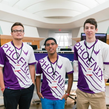 Three male students wearing shirts with the word 'Phoenix' at Rocket League spring open