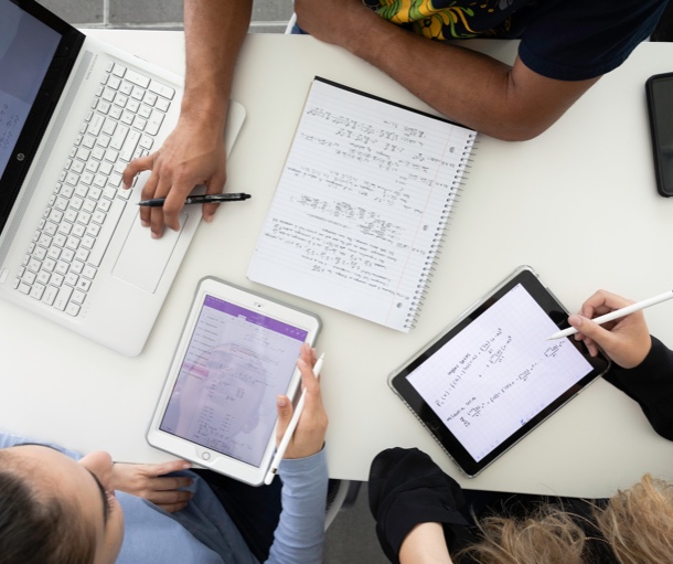 Overhead view of people working with laptop and tablets